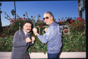 35mm vintage slide* 1985 ca USA Boxer Vinnie CURTO and composer John MADERA (3)  Diapositiva d'epoca, in formato 35 mm.CONDIZIONI: GOODE' severamente vietata la riproduzione. Tutti i diritti sono riservati.Nella diapositiva ICharta mette in vendita, sul negozio eBay e in esclusiva sul sito "icharta" il proprio archivio composto da numerose diapositive e negativi fotografici d'epoca, tutti originali e autentici, che attraversano la storia del costume italiano tra gli la fine degli anni Sessanta e Novanta.Si tratta di uno sguardo inedito sull'attualit&agrave;, la politica, la vita quotidiana, il gossip e la cultura, che fotografa il cambiamento della nazione in quest'ultimo scorcio del XX secolo. Un'occasione unica per il mercato del collezionismo, che vede finalmente disponibile un archivio eccezionale per vastit&agrave;, tematiche e condizioni, in un settore (il negativo fotografico e la diapositiva) di assoluta novit&agrave; e dalle interessanti prospettive di investimento. GOOD/buono   originale e autentica 1