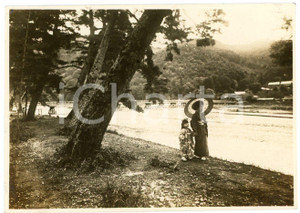 1935 ca KYOTO ARASHIYAMA Madre e figlia sulle rive del Fiume Katsura - Foto 11x7 Fotografia d'epoca.Sullo sfondo &egrave; visibile il Ponte Togetsukyo. FAIR/discreto Lievi smussature agli angoli Formato: 11x7 cm originale e autentica 1