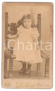 1870 ca. TORINO - Ritratto di bambina in piedi su sedia intarsiata - Foto BERRA  Fotografia d'epoca, su cartoncino rigido.FOTOGRAFO: G. B. BerraFotografia Subalpina Torino - corso Siccardi 6, via Cernaia 18 FAIR/discreto Lievi smussature e abrasioni angolari, residui di adesivo al verso, piccoli segni al lato destro Formato: 6 x 10 cm originale e autentica 1