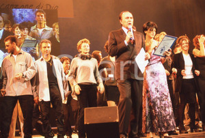 35mm vintage slide* 1999 GRANDE MEETING SANREMO Ettore ANDENNA e MARIADELE  Diapositiva d'epoca, in formato 35 mm.CONDIZIONI: GOODNella diapositiva compaiono i componenti del guppo vocale Emmanuel.E' severamente vietata la riproduzione. Tutti i diritti sono riservati.Nella diapositiva ICharta mette in vendita, sul negozio eBay e in esclusiva sul sito "icharta" il proprio archivio composto da numerose diapositive e negativi fotografici d'epoca, tutti originali e autentici, che attraversano la storia del costume italiano tra gli la fine degli anni Sessanta e Novanta.Si tratta di uno sguardo inedito sull'attualit&agrave;, la politica, la vita quotidiana, il gossip e la cultura, che fotografa il cambiamento della nazione in quest'ultimo scorcio del XX secolo. Un'occasione unica per il mercato del collezionismo, che vede finalmente disponibile un archivio eccezionale per vastit&agrave;, tematiche e condizioni, in un settore (il negativo fotografico e la diapositiva) di assoluta novit&agrave; e dalle interessanti prospettive di investimento. GOOD/buono   originale e autentica 1