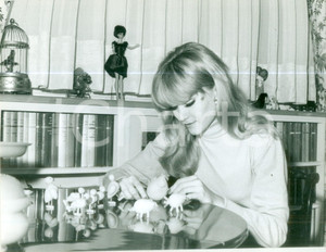 Fotografia d epoca originale 1965 ca PARIS FRANCE Mannequin bionda gioca con uccelli e maialini di legno 1