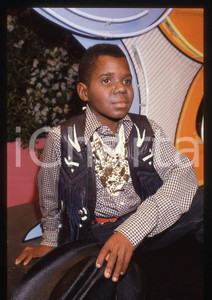 35mm vintage slide* 1985ca DRIVE IN Italia 1 GARY COLEMAN ospite della puntata   Diapositiva d'epoca, in formato 35 mm. CONDIZIONI: GOODTutti i diritti riservati.E' severamente vietata la riproduzione. ICharta mette in vendita, sul negozio eBay e in esclusiva sul sito "icharta" il proprio archivio composto da numerose diapositive e negativi fotografici d'epoca, tutti originali e autentici, che attraversano la storia del costume italiano tra gli la fine degli anni Sessanta e Novanta.Si tratta di uno sguardo inedito sull'attualità, la politica, la vita quotidiana, il gossip e la cultura, che fotografa il cambiamento della nazione in quest'ultimo scorcio del XX secolo. Un'occasione unica per il mercato del collezionismo, che vede finalmente disponibile un archivio eccezionale per vastità, tematiche e condizioni, in un settore (il negativo fotografico e la diapositiva) di assoluta novità e dalle interessanti prospettive di investimento. FORMATO: 35mm originale e autentica 1