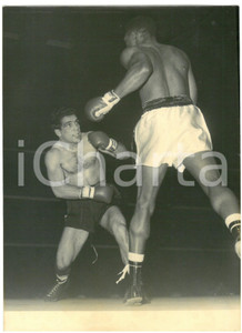 1956 MILANO - PUGILATO Duilio LOI sul ring contro Orlando ZULUETA - Foto 13x18 Fotografia d'epoca con didascalia coeva al verso.  CONDIZIONI: G (ma sovraimpressione e alone diffuso) CONDIZIONI: 13x18 cm    originale e autentica 1