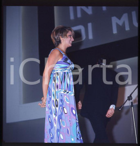 1970ca COSTUME MINA Alla presentazione di un evento DIAPOSITIVA ORIGINALE  Positivo fotografico su pellicola in formato cm 6 x 6  E' SEVERAMENTE VIETATA LA RIPRODUZIONE.TUTTI I DIRITTI SONO RISERVATI.ICharta mette in vendita, sul negozio eBay e in esclusiva sul sito "icharta" il proprio archivio composto da numerose diapositive e negativi fotografici d'epoca, tutti originali e autentici, che attraversano la storia del costume italiano tra gli la fine degli anni Sessanta e Novanta.Si tratta di uno sguardo inedito sull'attualità, la politica, la vita quotidiana, il gossip e la cultura, che fotografa il cambiamento della nazione in quest'ultimo scorcio del XX secolo. Un'occasione unica per il mercato del collezionismo, che vede finalmente disponibile un archivio eccezionale per vastità, tematiche e condizioni, in un settore (il negativo fotografico e la diapositiva) di assoluta novità e dalle interessanti prospettive di investimento. CONDIZIONI:FAIR/discretoFORMATO: cm 6 x 6 originale e autentica 1