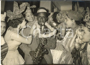 1957 PARIS Robert MAVZOUNY accolto da ragazze delle colonie francesi *Foto  Fotografia d'epoca con didascalia coeva al verso.   CONDIZIONI: G (ma lieve sovraimpressione circolare) FORMATO: 21x15 cm    originale e autentica 1