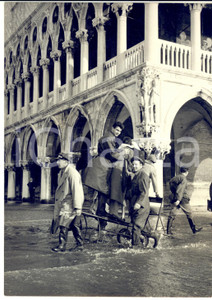 1955 ca VENEZIA Acqua alta - Trasporto su carriola in Piazza San Marco *Foto  Fotografia d'epoca con didascalia coeva al verso.   CONDIZIONI: G FORMATO: 13x18 cm     originale e autentica 1