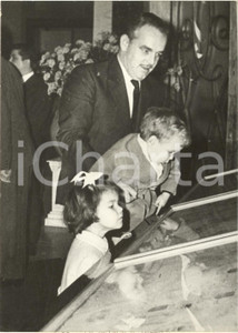 1960 MONACO Prince Rainier Ã  l'exposition des vitraux pour LES BAUX-DE-PROVENCE Fotografia d'epoca con didascalia coeva al verso, scattata in occasione della mostra delle vetrate offerte in dono alla chiesa locale.Sono ritratti i principi Caroline e Albert.CONDIZIONI: GFORMATO: 13x18 cm      originale e autentica 1