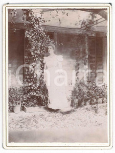 1910 ca ITALIA Donna in abito bianco in cortile - Casa rurale - Foto 9x12 cm  Fotografia d'epoca, su cartoncino rigido.  FAIR/discreto residui cartacei al verso Formato: 9x12 cm originale e autentica 1