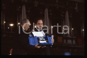 Jim BELUSHI Lello BERSANI - Cinema VENEZIA 1985 ca *35mm vintage slide 2 Diapositiva originale, in formato 35 mm.Jim Belushi è ritratto con il Leone d'Argento consegnato da Lello Bersani.Per i diritti rivolgersi a ICharta.E' severamente vietata la riproduzione. Tutti i diritti sono riservati.ICharta mette in vendita, sul negozio eBay e in esclusiva sul sito "icharta" il proprio archivio composto da numerose diapositive e negativi fotografici d'epoca, tutti originali e autentici, che attraversano la storia del costume tra la fine degli anni Sessanta e Novanta.Si tratta di uno sguardo inedito sull'attualità, la politica, la vita quotidiana, il gossip e la cultura, che fotografa il cambiamento della nazione in quest'ultimo scorcio del XX secolo. Un'occasione unica per il mercato del collezionismo, che vede finalmente disponibile un archivio eccezionale per vastità, tematiche e condizioni, in un settore (il negativo fotografico e la diapositiva) di assoluta novità e dalle interessanti prospettive di investimento.  GOOD/buono   originale e autentica 1