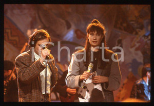 1990 ca Roberto VECCHIONI Kay RUSH * 35 mm vintage slide  Diapositiva d'epoca, in formato 35 mm.CONDIZIONI: GOODE' severamente vietata la riproduzione. Tutti i diritti sono riservati.ICharta mette in vendita, sul negozio eBay e in esclusiva sul sito "icharta" il proprio archivio composto da numerose diapositive e negativi fotografici d'epoca, tutti originali e autentici, che attraversano la storia del costume italiano tra gli la fine degli anni Sessanta e Novanta.Si tratta di uno sguardo inedito sull'attualità, la politica, la vita quotidiana, il gossip e la cultura, che fotografa il cambiamento della nazione in quest'ultimo scorcio del XX secolo. Un'occasione unica per il mercato del collezionismo, che vede finalmente disponibile un archivio eccezionale per vastità, tematiche e condizioni, in un settore (il negativo fotografico e la diapositiva) di assoluta novità e dalle interessanti prospettive di investimento.  GOOD/buono   originale e autentica 1