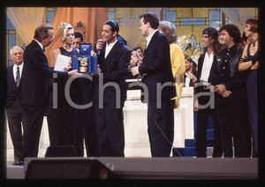 883 FIORELLO Max PEZZALI Festival Italiano 1993 - 35mm vintage slide 15 Diapositiva originale, in formato 35 mm.Scattata durante le riprese della trasmissione televisiva "Festival Italiano".Nella diapositive compare inoltre Mauro Repetto, Mike Bongiorno e Paola Barale.Per i diritti rivolgersi a ICharta.E' severamente vietata la riproduzione. Tutti i diritti sono riservati.ICharta mette in vendita, sul negozio eBay e in esclusiva sul sito "icharta" il proprio archivio composto da numerose diapositive e negativi fotografici d'epoca, tutti originali e autentici, che attraversano la storia del costume tra la fine degli anni Sessanta e Novanta.Si tratta di uno sguardo inedito sull'attualità , la politica, la vita quotidiana, il gossip e la cultura, che fotografa il cambiamento della nazione in quest'ultimo scorcio del XX secolo.Un'occasione unica per il mercato del collezionismo, che vede finalmente disponibile un archivio eccezionale per vastità , tematiche e condizioni, in un settore (il negativo fotografico e la diapositiva) di assoluta novitÃ e dalle interessanti prospettive di investimento. GOOD/buono   originale e autentica 1