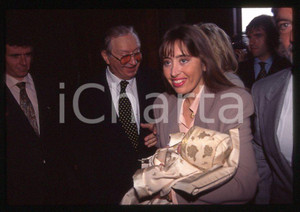 Romano ed Elisabetta MUSSOLINI Battesimo Marco SANTOBONI 1998 35mm vintage slide Diapositiva originale, in formato 35 mm.Per i diritti rivolgersi a ICharta.E' severamente vietata la riproduzione. Tutti i diritti sono riservati.ICharta mette in vendita, sul negozio eBay e in esclusiva sul sito "icharta" il proprio archivio composto da numerose diapositive e negativi fotografici d'epoca, tutti originali e autentici, che attraversano la storia del costume tra la fine degli anni Sessanta e Novanta.Si tratta di uno sguardo inedito sull'attualità , la politica, la vita quotidiana, il gossip e la cultura, che fotografa il cambiamento della nazione in quest'ultimo scorcio del XX secolo.Un'occasione unica per il mercato del collezionismo, che vede finalmente disponibile un archivio eccezionale per vastità , tematiche e condizioni, in un settore (il negativo fotografico e la diapositiva) di assoluta novità e dalle interessanti prospettive di investimento. CONDIZIONI:GOOD/buono originale e autentica 1