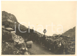 1926 PASUBIO Cimitero di guerra "Qui non si passa" - Pellegrinaggio mutilati  Rara e pregevole fotografia originale d'epoca, con didascalia manoscritta al verso che descrive l'evento:"Fotografia presa durante il pellegrinaggio vicentino dei mutilati al più alto cimitero di guerra detto delle "Sette Croci" sul Pasubio m. 2080 [attuale cimitero "Qui non si passa", dal nome della targa]. La fotografia riproduce il momento della messa da campo detta dal cappuccino padre fedele Pegoraro ex cappellano militare ferito e decorato sul Pasubio. La cerimonia organizzata dalla sezione vicentina dei Mutilati ha consacrato una nuova targa recante il motto  in sostituzione di una già esistente che ignoti vandali l'anno scorso sfregiarono con colpi di moschetto e con battito di sassi. Alla cerimonia parlarono l'on. Ignazio Chiarelli, mutilato di guerra, il generale Andrea Graziani, l'eroe del Pasubio, il padre Fedele Pegoraro, il prof. Stefani, il col. Ferraro. La manifestazione, svoltasi domenica 12 c.m., è riuscita una vera apoteosi per il Duce al quale i mutilati giurarono indefettibile amore". FAIR/discreto minima traccia centrale di colla Formato: 24x18 cm originale e autentica 1