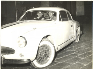 1959 GENOVA Piazza Fossatello - Mario CAROTENUTO in ALFA ROMEO con gomma a terra Fotografia d'epoca con didascalia coeva al verso. CONDIZIONI: G (ma  sovraimpressione al margine inferiore) FORMATO: 24x18 cm    originale e autentica 1