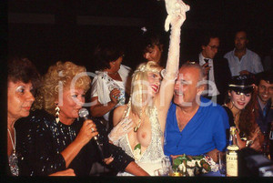 1980 ca CICCIOLINA Ilona STALLER Riccardo SCHICCHI 35 mm vintage slide Diapositiva d'epoca, in formato 35 mm.Nella diapositiva compaiono inoltre Ramba e M. LefakisCONDIZIONI: GOODE' severamente vietata la riproduzione. Tutti i diritti sono riservati.Nella diapositiva ICharta mette in vendita, sul negozio eBay e in esclusiva sul sito "icharta" il proprio archivio composto da numerose diapositive e negativi fotografici d'epoca, tutti originali e autentici, che attraversano la storia del costume italiano tra gli la fine degli anni Sessanta e Novanta.Si tratta di uno sguardo inedito sull'attualità , la politica, la vita quotidiana, il gossip e la cultura, che fotografa il cambiamento della nazione in quest'ultimo scorcio del XX secolo. Un'occasione unica per il mercato del collezionismo, che vede finalmente disponibile un archivio eccezionale per vastità , tematiche e condizioni, in un settore (il negativo fotografico e la diapositiva) di assoluta novità e dalle interessanti prospettive di investimento.  GOOD/buono   originale e autentica 1 1980 ca CICCIOLINA Ilona STALLER Riccardo SCHICCHI 35 mm vintage slide Diapositiva d'epoca, in formato 35 mm.Nella diapositiva compaiono inoltre Ramba e M. LefakisCONDIZIONI: GOODE' severamente vietata la riproduzione. Tutti i diritti sono riservati.Nella diapositiva ICharta mette in vendita, sul negozio eBay e in esclusiva sul sito "icharta" il proprio archivio composto da numerose diapositive e negativi fotografici d'epoca, tutti originali e autentici, che attraversano la storia del costume italiano tra gli la fine degli anni Sessanta e Novanta.Si tratta di uno sguardo inedito sull'attualità , la politica, la vita quotidiana, il gossip e la cultura, che fotografa il cambiamento della nazione in quest'ultimo scorcio del XX secolo. Un'occasione unica per il mercato del collezionismo, che vede finalmente disponibile un archivio eccezionale per vastità , tematiche e condizioni, in un settore (il negativo fotografico e la diapositiva) di assoluta novità e dalle interessanti prospettive di investimento.  GOOD/buono   originale e autentica 1