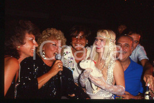 1980 ca CICCIOLINA Ilona STALLER Michalis LEFAKIS *35 mm vintage slide 3 Diapositiva d'epoca, in formato 35 mm.CONDIZIONI: GOODE' severamente vietata la riproduzione. Tutti i diritti sono riservati.Nella diapositiva ICharta mette in vendita, sul negozio eBay e in esclusiva sul sito "icharta" il proprio archivio composto da numerose diapositive e negativi fotografici d'epoca, tutti originali e autentici, che attraversano la storia del costume italiano tra gli la fine degli anni Sessanta e Novanta.Si tratta di uno sguardo inedito sull'attualità , la politica, la vita quotidiana, il gossip e la cultura, che fotografa il cambiamento della nazione in quest'ultimo scorcio del XX secolo. Un'occasione unica per il mercato del collezionismo, che vede finalmente disponibile un archivio eccezionale per vastità , tematiche e condizioni, in un settore (il negativo fotografico e la diapositiva) di assoluta novità e dalle interessanti prospettive di investimento.  GOOD/buono   originale e autentica 1 1980 ca CICCIOLINA Ilona STALLER Michalis LEFAKIS *35 mm vintage slide 3 Diapositiva d'epoca, in formato 35 mm.CONDIZIONI: GOODE' severamente vietata la riproduzione. Tutti i diritti sono riservati.Nella diapositiva ICharta mette in vendita, sul negozio eBay e in esclusiva sul sito "icharta" il proprio archivio composto da numerose diapositive e negativi fotografici d'epoca, tutti originali e autentici, che attraversano la storia del costume italiano tra gli la fine degli anni Sessanta e Novanta.Si tratta di uno sguardo inedito sull'attualità , la politica, la vita quotidiana, il gossip e la cultura, che fotografa il cambiamento della nazione in quest'ultimo scorcio del XX secolo. Un'occasione unica per il mercato del collezionismo, che vede finalmente disponibile un archivio eccezionale per vastità , tematiche e condizioni, in un settore (il negativo fotografico e la diapositiva) di assoluta novità e dalle interessanti prospettive di investimento.  GOOD/buono   originale e autentica 1