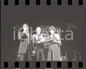 1976 VOTA LA VOCE Gigi VESIGNA e Dino SARTI sul palco (2) NEGATIVO ORIGINALE Negativo originale in bianco e nero su pellicola.  E' SEVERAMENTE VIETATA LA RIPRODUZIONE.TUTTI I DIRITTI SONO RISERVATI.ICharta mette in vendita, sul negozio eBay e in esclusiva sul sito "icharta" il proprio archivio composto da numerose diapositive e negativi fotografici d'epoca, tutti originali e autentici.Si tratta di uno sguardo inedito sull'attualità, la politica, la vita quotidiana, il gossip e la cultura, che fotografa il cambiamento della nazione (e non solo) tra il 1890 ed il 1990 circa. Un'occasione unica per il mercato del collezionismo, che vede finalmente disponibile un archivio eccezionale per vastità, tematiche e condizioni, in un settore (il negativo fotografico e la diapositiva) di assoluta novità e dalle interessanti prospettive di investimento. FAIR/discreto  Formato: 35mm originale e autentica 1