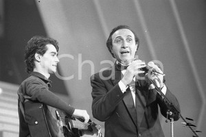 1987 SANREMO Pippo BAUDO presenta Nino BUONOCORE (2) NEGATIVO ORIGINALE Negativo originale in bianco e nero, su pellicola, in formato 35mm  E' SEVERAMENTE VIETATA LA RIPRODUZIONE.TUTTI I DIRITTI SONO RISERVATI.ICharta mette in vendita, sul negozio eBay e in esclusiva sul sito "icharta" il proprio archivio composto da numerose diapositive e negativi fotografici d'epoca, tutti originali e autentici, che attraversano la storia del costume italiano tra gli la fine degli anni Sessanta e Novanta.Si tratta di uno sguardo inedito sull'attualità, la politica, la vita quotidiana, il gossip e la cultura, che fotografa il cambiamento della nazione in quest'ultimo scorcio del XX secolo. Un'occasione unica per il mercato del collezionismo, che vede finalmente disponibile un archivio eccezionale per vastità, tematiche e condizioni, in un settore (il negativo fotografico e la diapositiva) di assoluta novità e dalle interessanti prospettive di investimento.  FAIR/discreto  FORMATO: 35mm originale e autentica 1