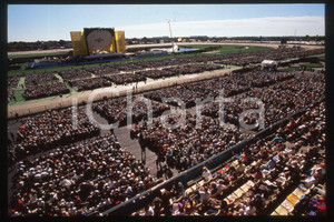 35mm vintage slide* 1995 BROOKLYN Aqueduct Racetrack - People waiting for Pope 1  Diapositiva d'epoca, in formato 35 mm.CONDIZIONI: GOODE' severamente vietata la riproduzione. Tutti i diritti sono riservati.Nella diapositiva ICharta mette in vendita, sul negozio eBay e in esclusiva sul sito "icharta" il proprio archivio composto da numerose diapositive e negativi fotografici d'epoca, tutti originali e autentici, che attraversano la storia del costume italiano tra gli la fine degli anni Sessanta e Novanta.Si tratta di uno sguardo inedito sull'attualit&agrave;, la politica, la vita quotidiana, il gossip e la cultura, che fotografa il cambiamento della nazione in quest'ultimo scorcio del XX secolo. Un'occasione unica per il mercato del collezionismo, che vede finalmente disponibile un archivio eccezionale per vastit&agrave;, tematiche e condizioni, in un settore (il negativo fotografico e la diapositiva) di assoluta novit&agrave; e dalle interessanti prospettive di investimento.   FAIR/discreto   originale e autentica 1