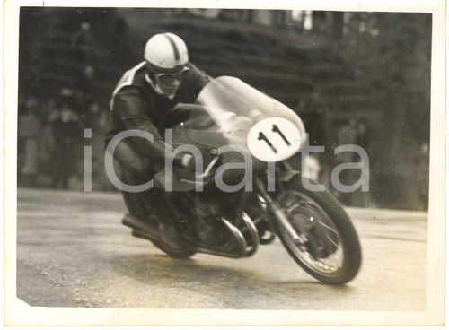 1956 ISOLA DI MAN JUNIOR TT - John SURTEES su moto MV AGUSTA al Quarterbridge Fotografia d'epoca con didascalia coeva al verso.  CONDIZIONI: POOR (lievi sovraimpressioni; lievi ondulature; macchia nella parte inferiore) FORMATO: 20x15 cm     originale e autentica 1