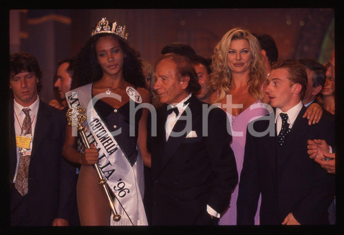 35mm vintage slide* 1996 MISS ITALIA Alba PARIETTI Jury CHECHI Denny MENDEZ (1)  Diapositiva d'epoca, in formato 35 mm. Nella diapositiva compaiono Alba Parietti, Jury Chechi, Denny M&eacute;ndez ed Enzo Mirigliani. CONDIZIONI: GOOD Tutti i diritti riservati.E' severamente vietata la riproduzione. ICharta mette in vendita, sul negozio eBay e in esclusiva sul sito "icharta" il proprio archivio composto da numerose diapositive e negativi fotografici d'epoca, tutti originali e autentici, che attraversano la storia del costume italiano tra gli la fine degli anni Sessanta e Novanta.Si tratta di uno sguardo inedito sull'attualit&agrave;, la politica, la vita quotidiana, il gossip e la cultura, che fotografa il cambiamento della nazione in quest'ultimo scorcio del XX secolo. Un'occasione unica per il mercato del collezionismo, che vede finalmente disponibile un archivio eccezionale per vastit&agrave;, tematiche e condizioni, in un settore (il negativo fotografico e la diapositiva) di assoluta novit&agrave; e dalle interessanti prospettive di investimento.  originale e autentica 1