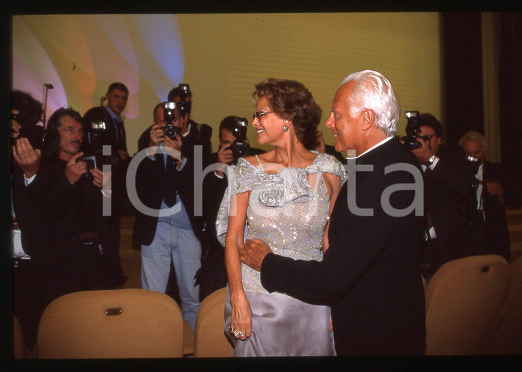 Giorgio ARMANI e Claudia CARDINALE FESTIVAL VENEZIA 1998 * 35 mm vintage slide 2  Diapositiva d'epoca, in formato 35 mm.CONDIZIONI: GOODE' severamente vietata la riproduzione. Tutti i diritti sono riservati.ICharta mette in vendita, sul negozio eBay e in esclusiva sul sito "icharta" il proprio archivio composto da numerose diapositive e negativi fotografici d'epoca, tutti originali e autentici, che attraversano la storia del costume italiano tra gli la fine degli anni Sessanta e Novanta.Si tratta di uno sguardo inedito sull'attualità, la politica, la vita quotidiana, il gossip e la cultura, che fotografa il cambiamento della nazione in quest'ultimo scorcio del XX secolo. Un'occasione unica per il mercato del collezionismo, che vede finalmente disponibile un archivio eccezionale per vastità, tematiche e condizioni, in un settore (il negativo fotografico e la diapositiva) di assoluta novità e dalle interessanti prospettive di investimento.  GOOD/buono   originale e autentica 1