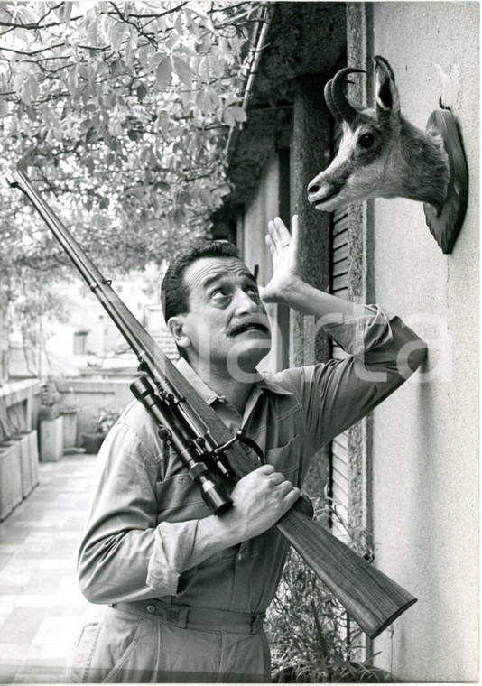 1964 MILANO Walter MARCHESELLI con un fucile ammira un suo trofeo di caccia