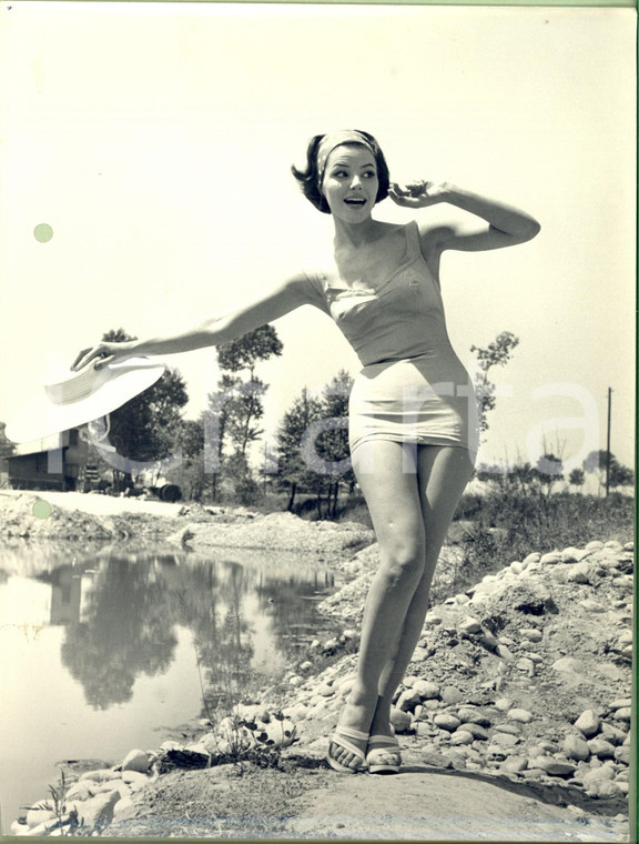 1960 ca STORIA DELLA MODA Modella scherza in costume lungo uno stagno *Foto 