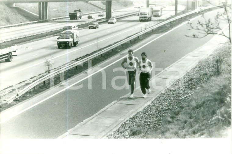 1990 LONDON Podisti corrono in autostrada con maschera antigas *Fotografia