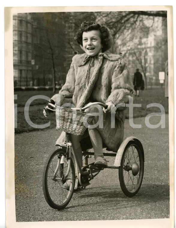 1953 LONDON Child conductor Giannella DE MARCO in fur coat riding a tricycle