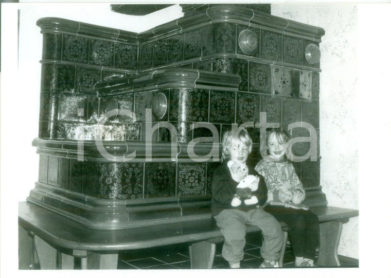1985 ca SUNDGAU (FRANCE) ARTIGIANATO Bambini su una stufa KACHELOFEN *Fotografia