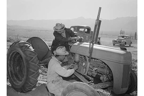 Tractor repair: Driver Benji Iguchi, Mechanic Henry Hanawa, Manzanar Relocation Center, California