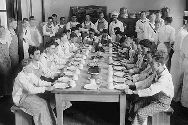 Naval Cadets sit at long table with bowls in front