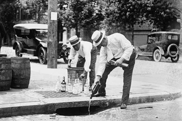 Agents Pouring liquor down a sewer on the Street