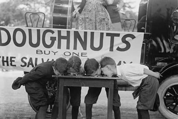 Boys Chow Down on a Table in a Donut Eating Contest