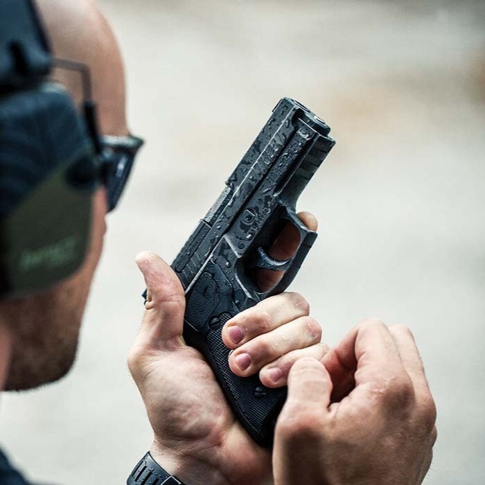 man loads sig p229 pistol