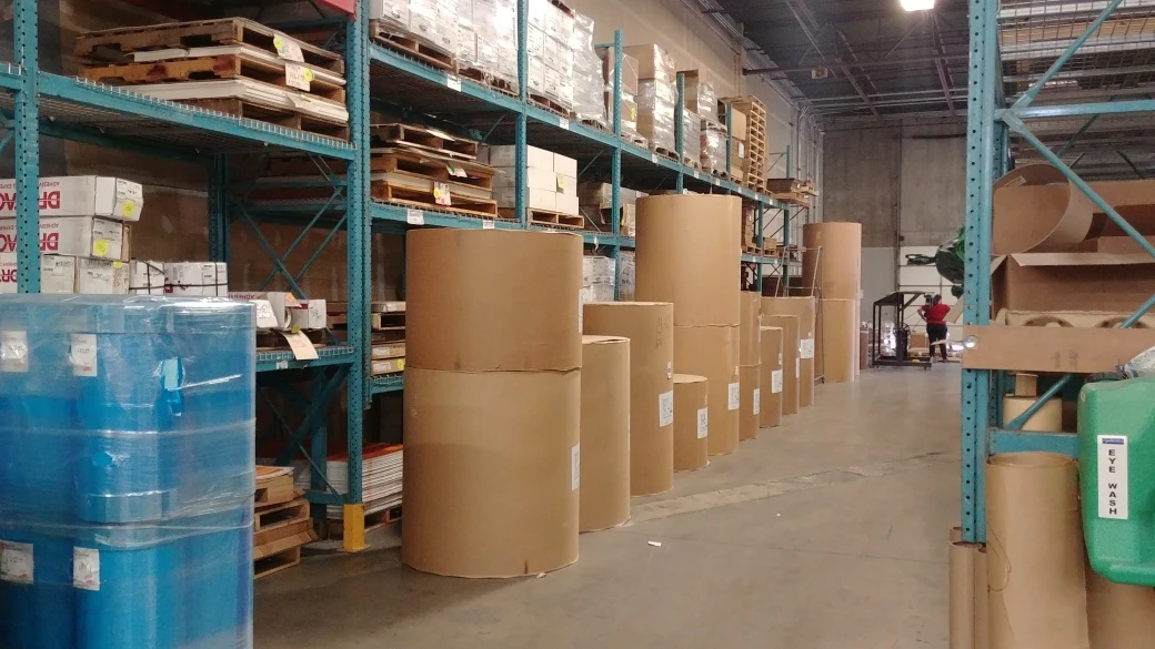 Warehouse racks of kraft rolls and wrapped finished goods