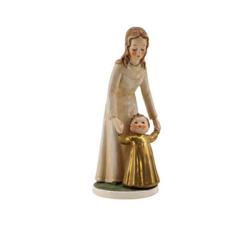 Goebel 1966 Porcelain Mother And Child titled "Her Shining Hour" 

Lovely, timeless statue of a Mom helping her child walk. 

Goebel is a German based porcelain maker. Their best known artist is Hummel. This piece is distinctly Goebel quality.