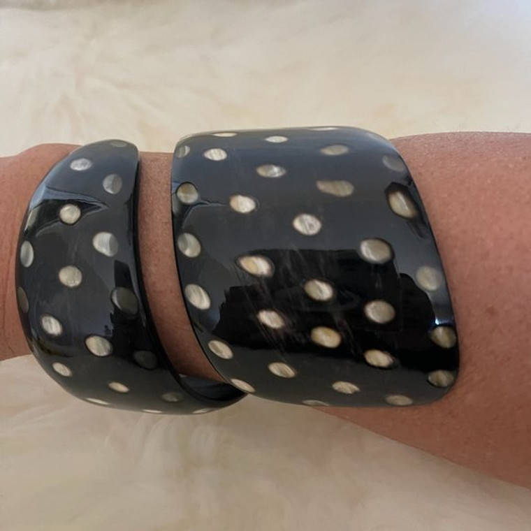 Statement Swirl Bracelet with polka dots dancing on a black water buffalo horn background.