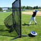Young baseball player hitting balls into a sock net