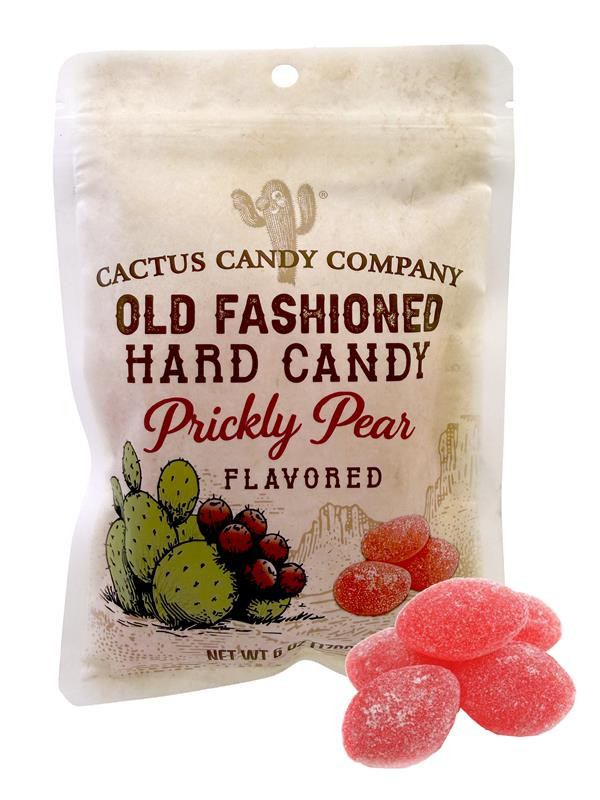 Package of Cactus Candy Company Old Fashioned Hard Candy, Prickly Pear flavored. The stand-up pouch features a vintage Western-style design with a cactus illustration, desert landscape artwork, and bold product lettering. Several pink, sugar-coated hard candy pieces are displayed in front of the package, showcasing the candy's prickly pear flavor and color.