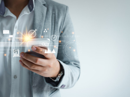 An image of a business man holding a mobile phone with an overlay of digital charts