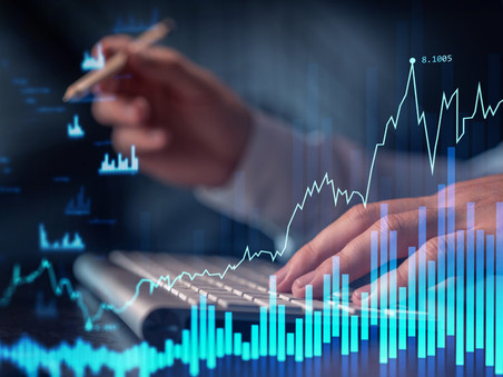 A graphic of digital bar charts over top of a man’s hands working on a computer keyboard.