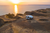 Photo of van with Starlink on roof parked on a scenic lookout overlooking the ocean at sunset