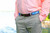 Image of a man wearing the Belted Cow Repp Stripe Leather Tab Belt in light blue and white. 