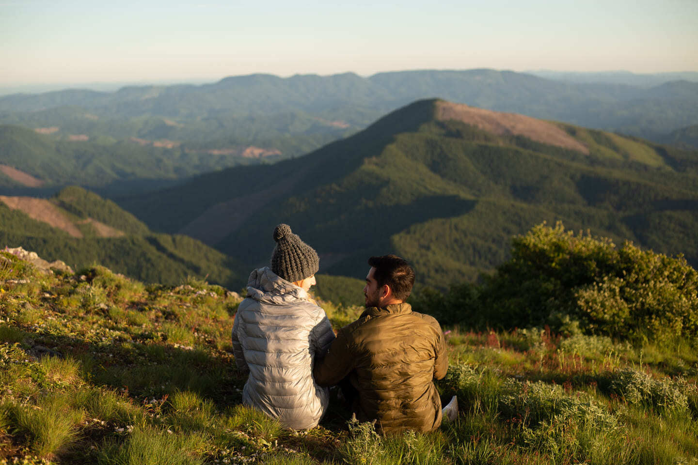 man and woman wearing winter outerwear sitting in the field