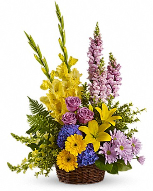 Tall flower arrangement in mixed flowers, in purple and yellow tones delivered by Italian florists.
