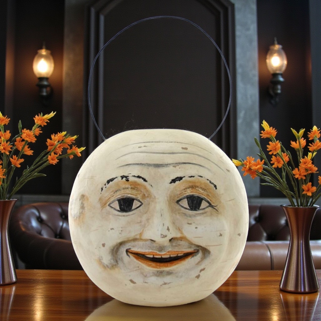 Paper mache Fairytale Moon candy bucket with smiling moon face and wire handle.
Vintage-style round moon bucket with painted eyes, soft smile, and aged details.
10 inch paper mache moon candy bucket for wrapped treats and Halloween displays.