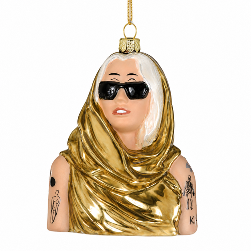 Glass pop-star bust ornament with black sunglasses and blonde hair.
Music-themed hanging ornament with gold draped outfit and tattoo-style arm details.
4.25 inch Miley Cyrus glass ornament on a white background.