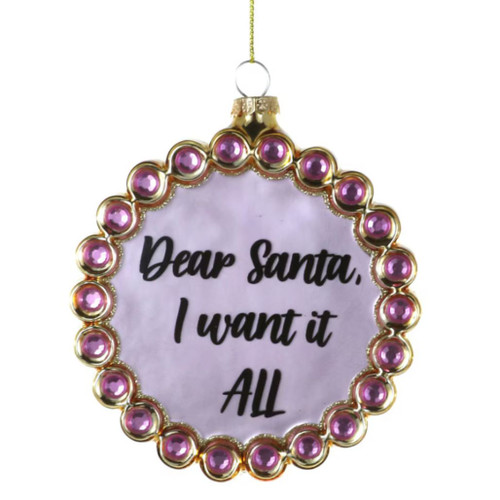 Round glass ornament with “Dear Santa, I Want It All” text.
Pink and gold Christmas ornament with jewel-style border and hanging cord.
Glass wish list ornament with black lettering and pink accent details.